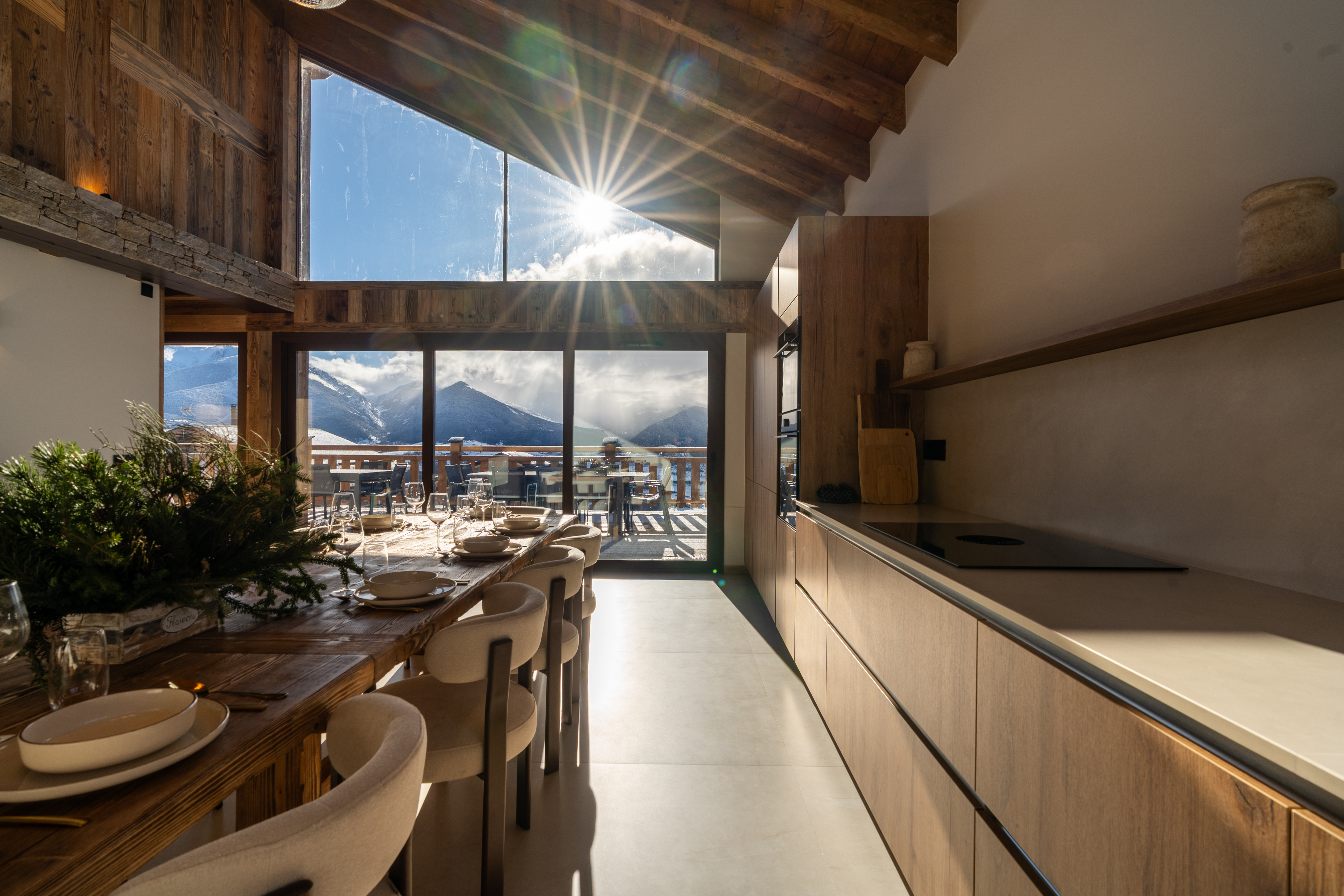 Cuisine ouverte sur la table bergère, soleil rasant à travers les baies